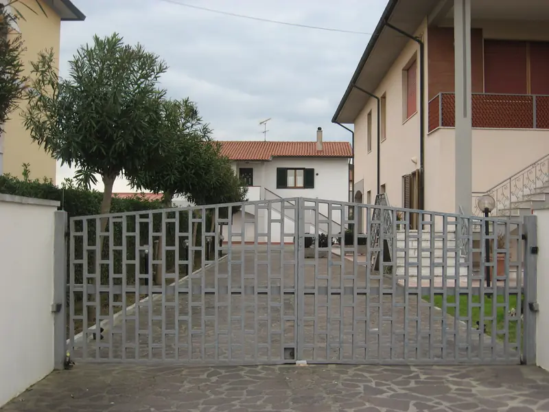 Cancello carrabile automatico a disegno geometrico su viale condominiale